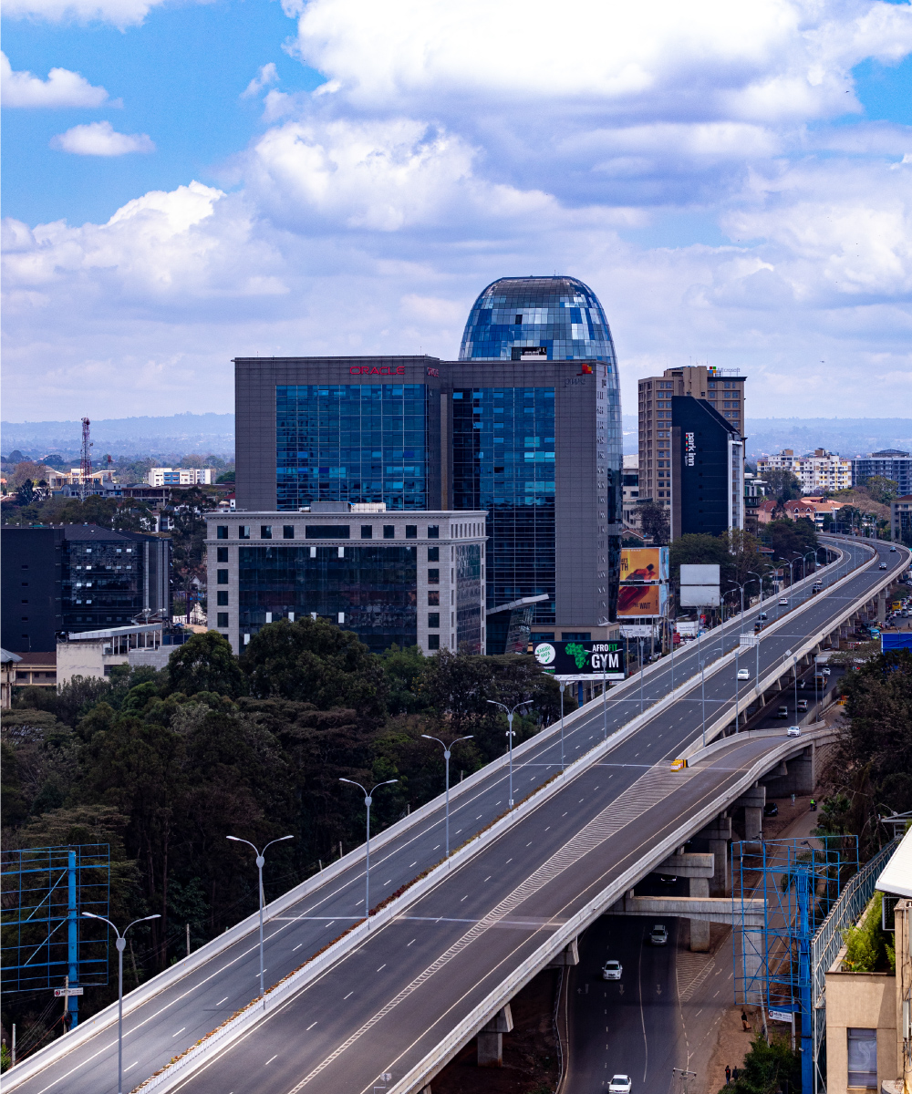 Elevated highway through Nairobi with modern glass buildings and urban skyline.